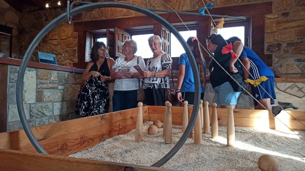 Unas mujeres mayores cantan y hablan en un museo de juegos tradicionales.